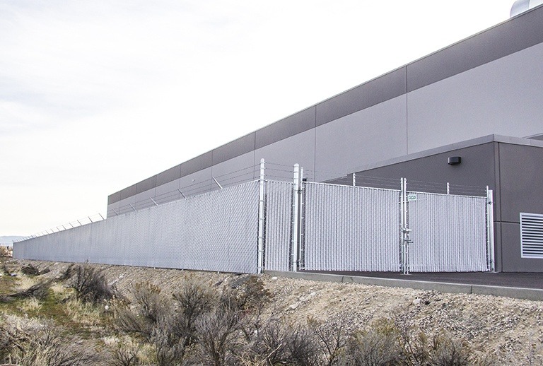 Commercial chain link perimeter fencing with security wire installed at an industrial warehouse facility in Texas
