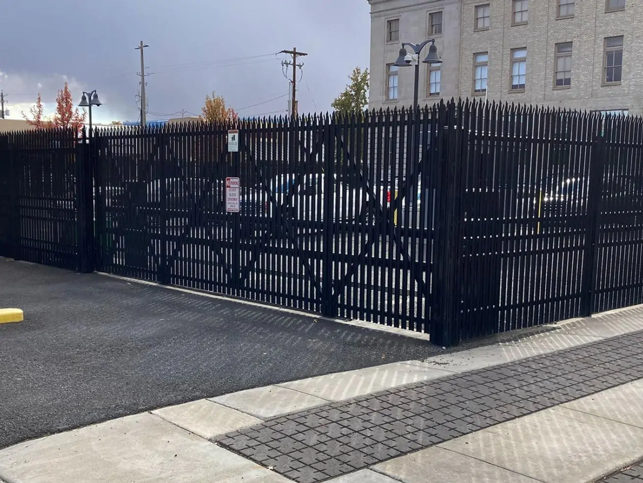 Commercial security fencing system with automated access control pedestal and reinforced steel perimeter gate installed at an urban facility in Texas