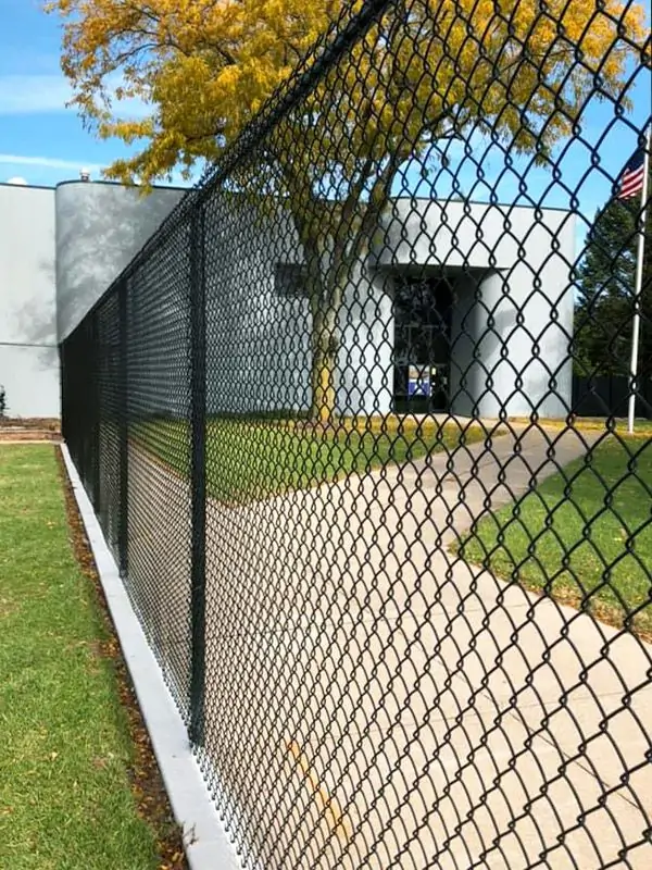 Black vinyl-coated chain link fence at a commercial property.