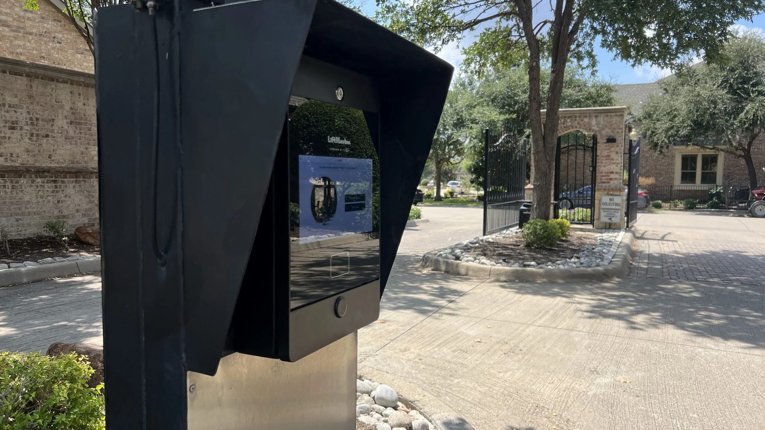 Video intercom and telephone entry pedestal at a gated community entrance.